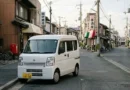 Kei van (keibann) compact Japanese mini van parked on a quiet urban street with realistic natural lighting
