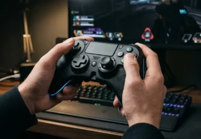 A gamer holding the Under Growth Games UGGControMan Controller in front of a gaming monitor