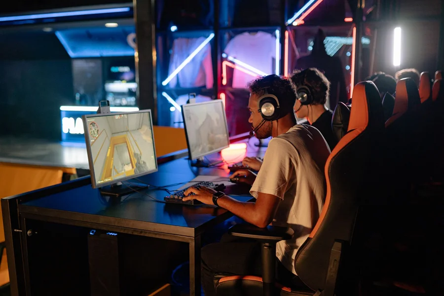 Modern computer gaming desk setup with glowing keyboard and wireless controller